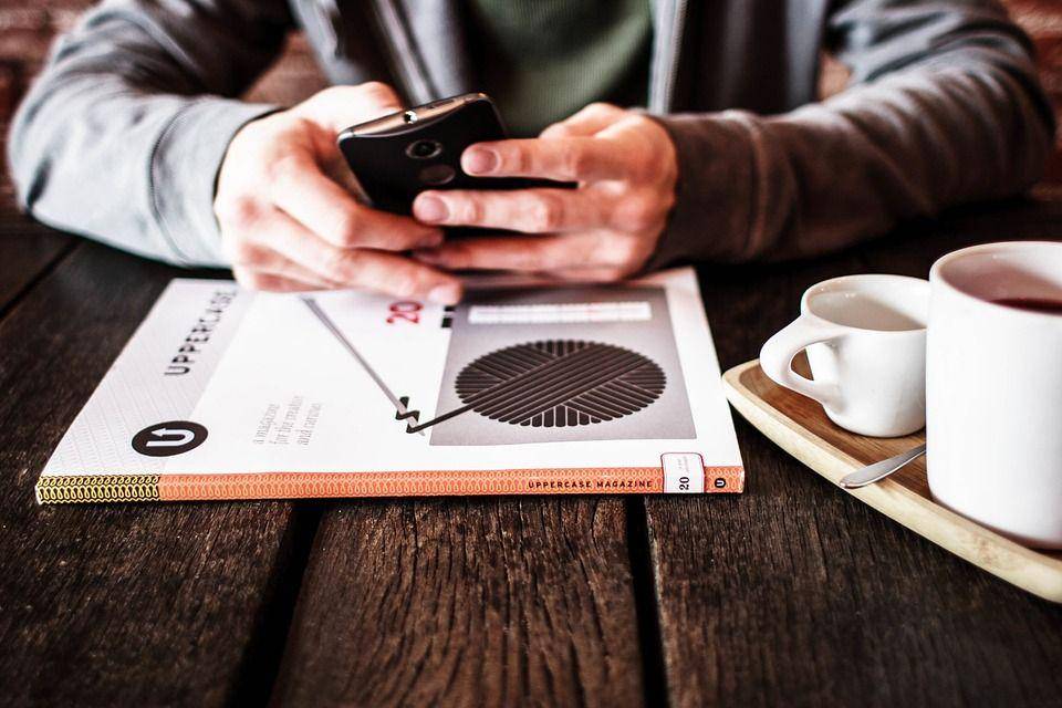 lalaki berjas hitam sedang menikmati kecanggihan smartphone
