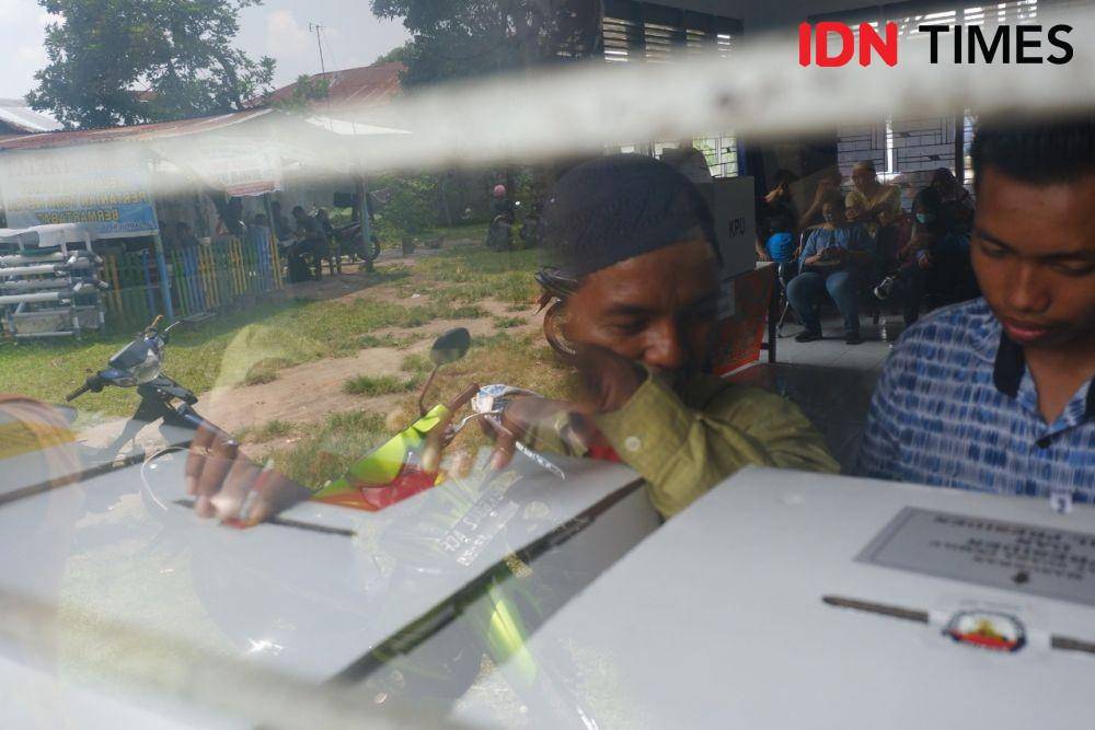 Seorang pemilih disabilitas netra memasukkan surat suara ke dalam kotak saat Pemilihan Gubernur Sumut 2018 (IDN Times/Prayugo Utomo)