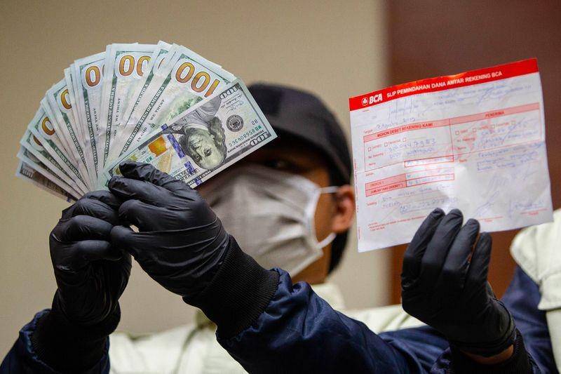 (Penyidik menunjukkan duit dollar barang bukti OTT terhadap kader PDIP) ANTARA FOTO/Dhemas Reviyanto