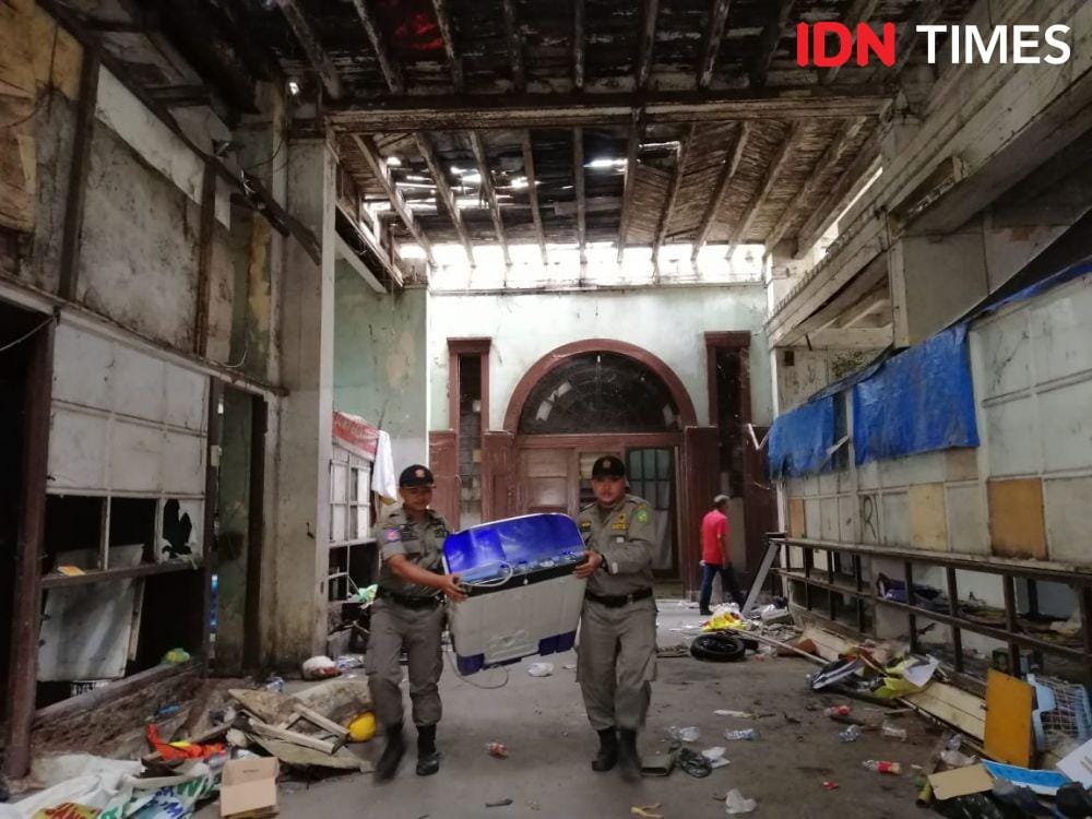 Petugas Satpol PP membersihkan Warenhuis (IDN Times/Prayugo Utomo)