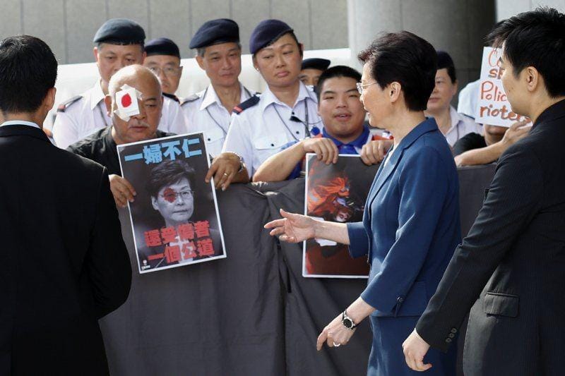 Carrie Lam berjalan di depan pembuat petisi di luar kantornya di Hong Kong. ANTARA FOTO/REUTERS/Thomas Peter