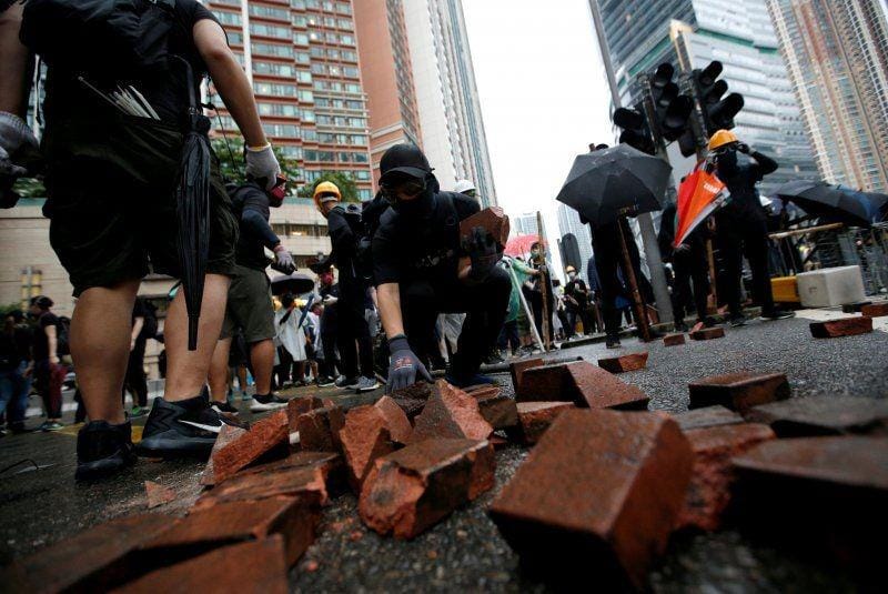 Pengunjuk rasa mengumpulkan batu bata saat bentrok dengan polisi huru-hara di Hong Kong. ANTARA FOTO/REUTERS/Willy Kurniawan