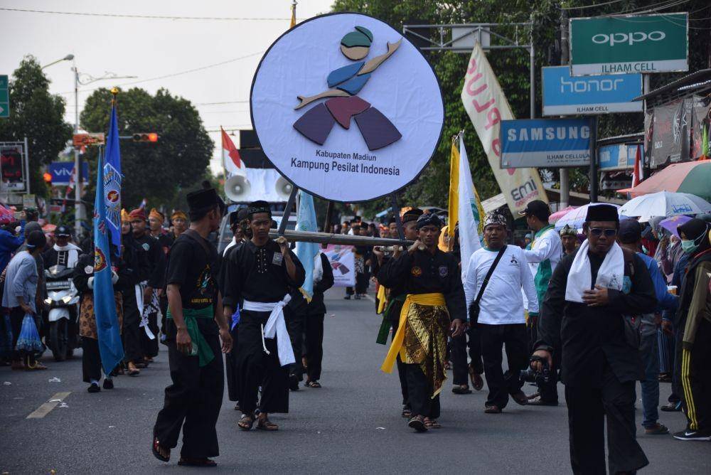 Para pesilat membawa memanggul logo 'Kabupaten Madiun Kampung Pesilat' dalam karnaval memperingati HUT ke-74 RI. Dok.IDN Times/Istimewa