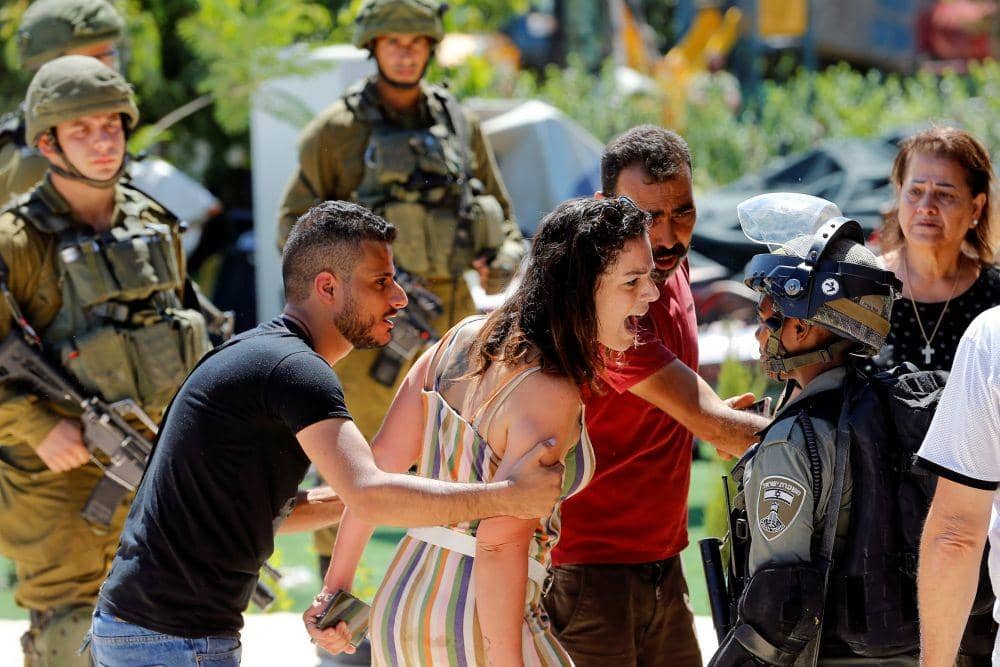 Seorang perempuan Palestina berdebat dengan polisi Israel karena peruntuhan bangunan di Tepi Barat pada 26 Agustus 2019. ANTARA FOTO/REUTERS/Mussa Qawasma