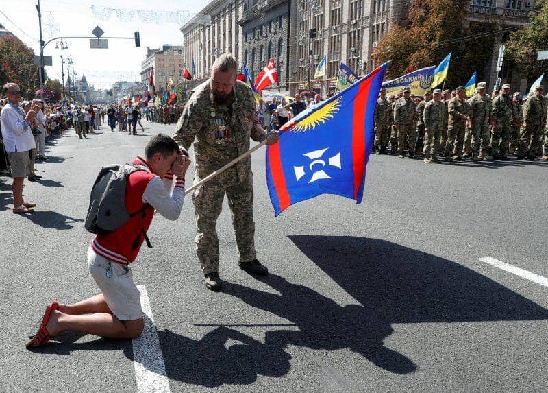 Seorang pria berlutut saat "March of Defenders of Ukraine" sebagai bagian dari perayaan Hari Kemerdekaan Ukraina di Kiev, Ukraina pada 24 Agustus 2019. ANTARA FOTO/REUTERS/Valentyn Ogirenko