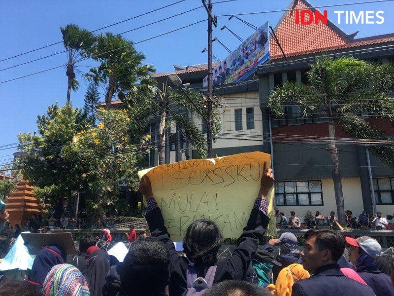 Seorang mahasiswa dari sebuah kampus membawa poster pada demonstrasi di depan gedung DPRD Provinsi Jawa Timur pada 26 September 2019. IDN Times/Rosa Folia