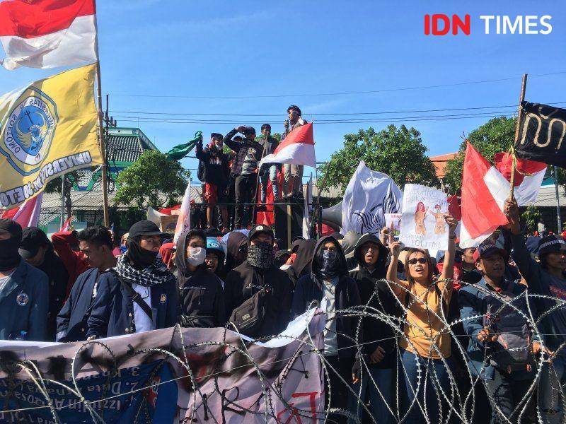 Seorang demonstran perempuan menunjukkan poster mendukung otonomi perempuan terhadap tubuhnya sendiri pada unjuk rasa di depan gedung DPRD Provinsi Jawa Timur pada 26 September 2019. IDN Times/Rosa Folia