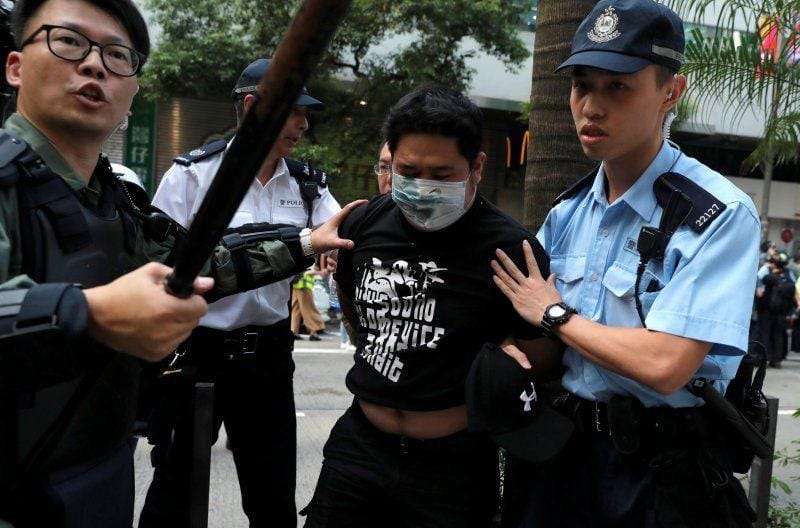 Seorang pria dikawal polisi saat pengunjuk rasa anti pemerintah dan demonstran pro Tiongkok bentrok di distrik Wan Chai, Hong Kong, pada 1 Oktober 2019. ANTARA FOTO/REUTERS/Susana Vera