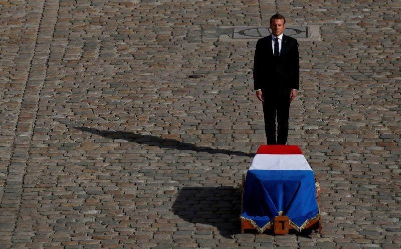 Presiden Prancis Emmanuel Macron berdiri di depan peti jenazah mantan presiden Prancis Jacques Chirac yang berbalut bendera dalam upacara penghormatan pemakaman militer di Hotel des Invalides saat hari berkabung nasional di Paris, Prancis, pada 30 September 2019. ANTARA FOTO/REUTERS/Gonzalo Fuentes
