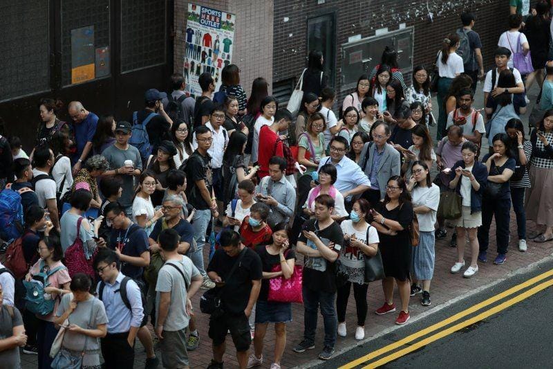 Warga mengantri saat mereka menunggu bus di dekat stasiun MTR Kwun Tong yang ditutup setelah perusakan oleh pengunjuk rasa anti-pemerintah, di Hong Kong, pada 9 Oktober 2019. ANTARA FOTO/REUTERS/Athit Perawongmetha