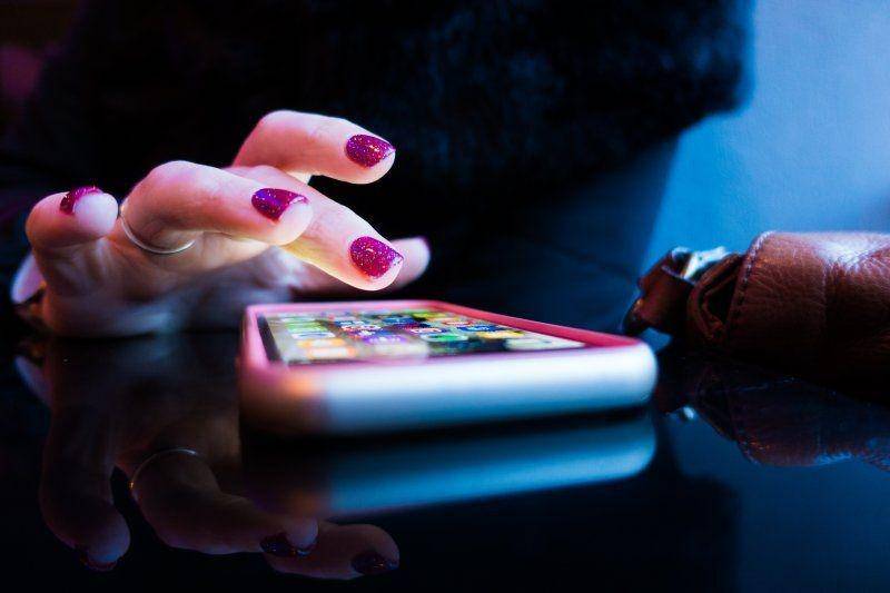 Ilustrasi seorang perempuan sedang menggunakan handphone. unsplash.com/Rob Hampson