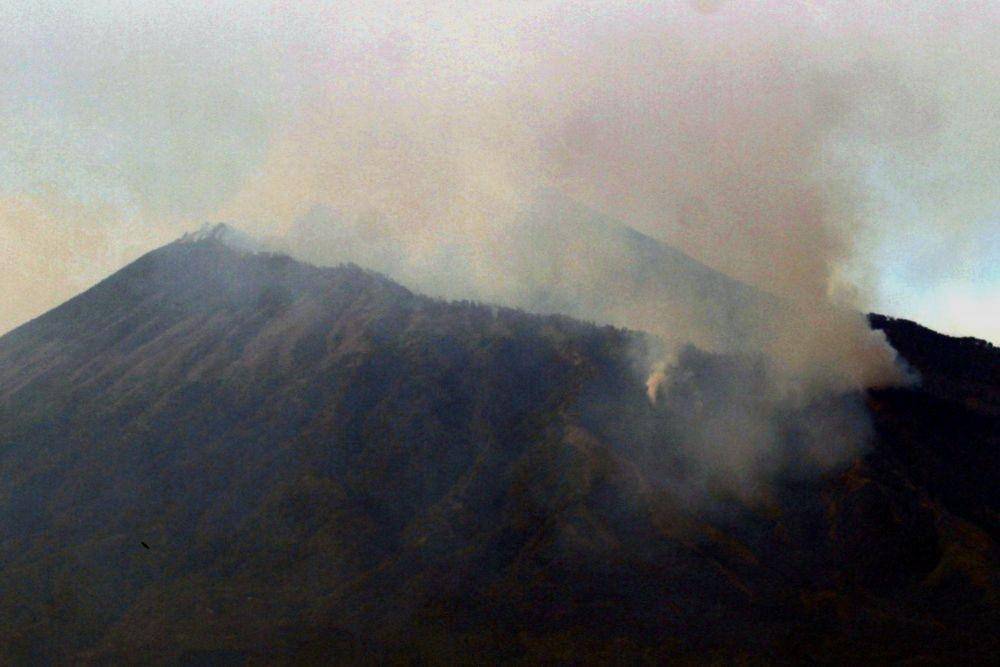 Asap membubung dari lokasi kebakaran hutan di lereng Gunung Arjuno terlihat dari Desa Landungsari, Malang, Jawa Timur, Jumat (11/10). ANTARA FOTO/Ari Bowo Sucipto