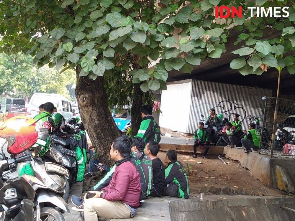 Ilustrasi ojol sedang menunggu pesanan. IDN Times/Dini suciatiningrum