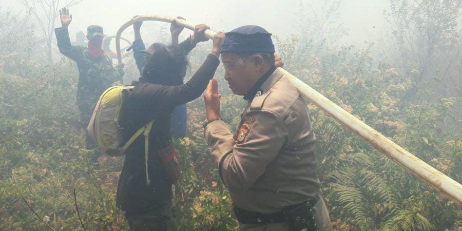 Petugas dari Kepolisian berusaha memadamkan api yang membakarw kawasan hutan di kaki Gunung Bawakaraeng, Gowa, Sulawesi Selatan, Selasa (22/10)/Istimewa