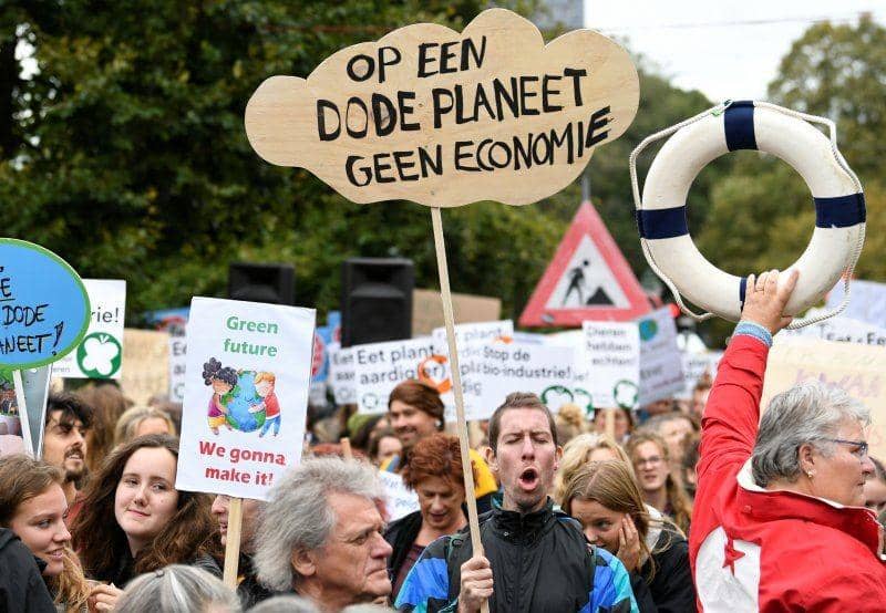 Warga yang mengikuti aksi membawa spanduk dengan tulisan "Di planet mati tidak ada ekonomi" menuntut aksi atas perubahan iklim, di Den Haag, Belanda, pada 27 September 2019. ANTARA FOTO/REUTERS/Piroschka van de Wouw