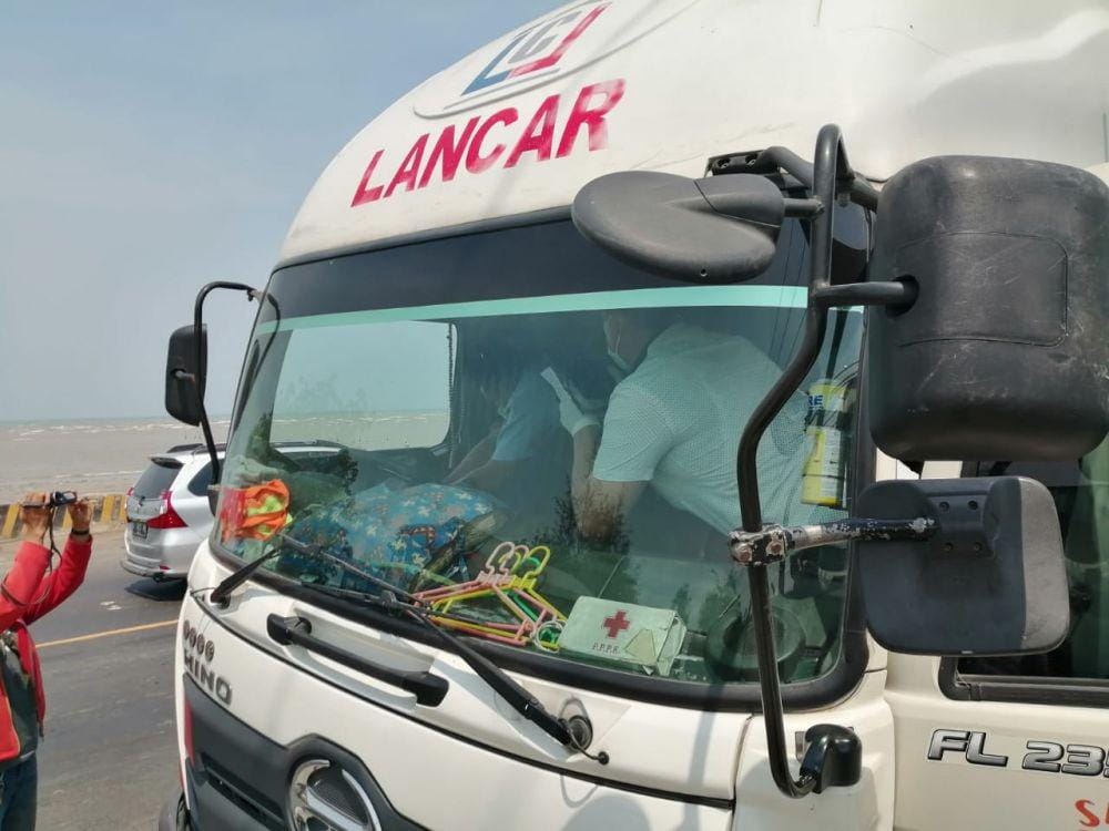 Petugas kepolisian Polsek Jenu mengevakuasi korban dari dalam mobil truk yang dikendarai (24/10). IDN Times/Imron