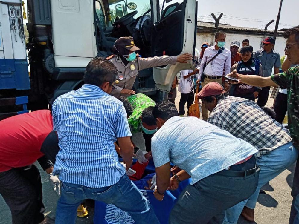 Petugas kepolisian Polsek Jenu mengevakuasi korban dari dalam mobil di Kecamatan Jenu Tuban (24/10). IDN Times/Imron
