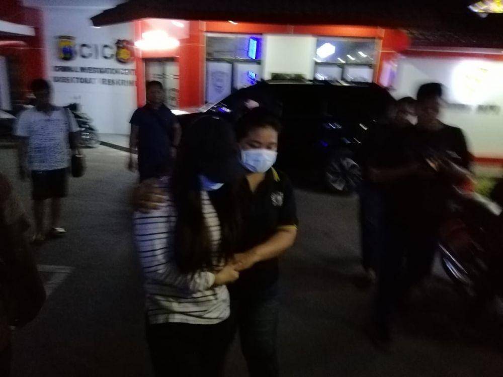 PA (kiri) dikawal salah seorang penyidik usai menjalani pemeriksaan di Ditreskrimum Polda Jatim, Minggu (27/10). IDN Times/Istimewa