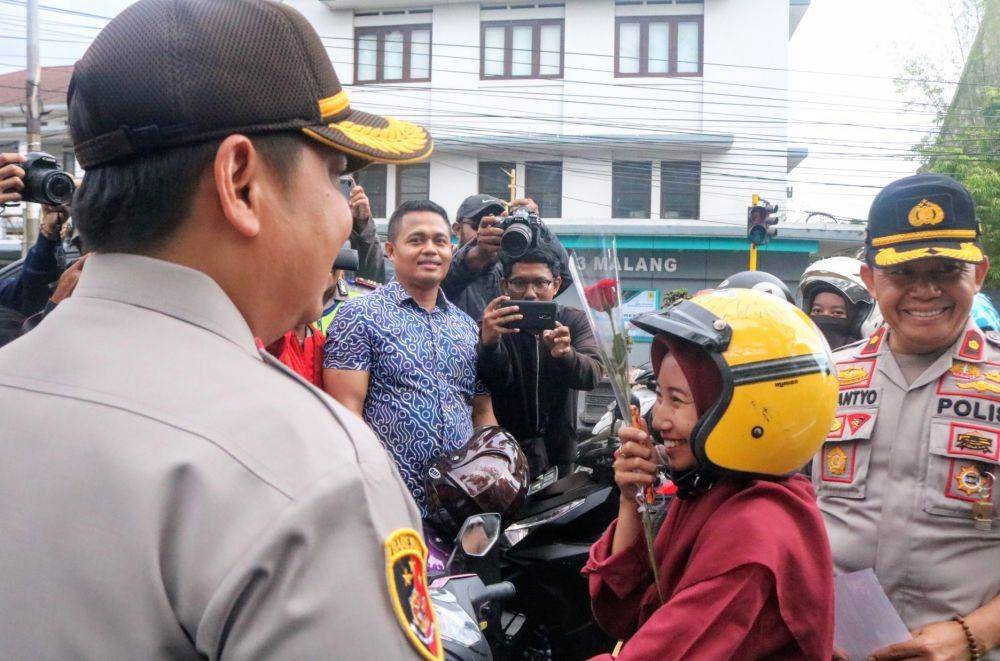 Kapolres Malang Kota, AKBP Dony Alexander (kiri) membagikan helm kepada pengendara motor di sekitar kawasan Jl Basuki Rachmat Kota Malang, Selasa (29/10/2019). IDN Times/ Alfi Ramadana