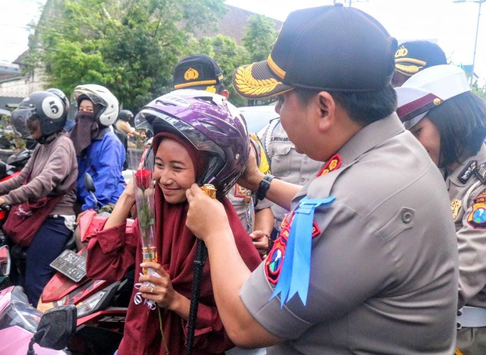 Kapolres Malang Kota, AKBP Dony Alexander memakaikan helm kepada pengendara yang menggunakan helm tak standart, Selasa (29/10/2019). IDN Times/ Alfi Ramadana