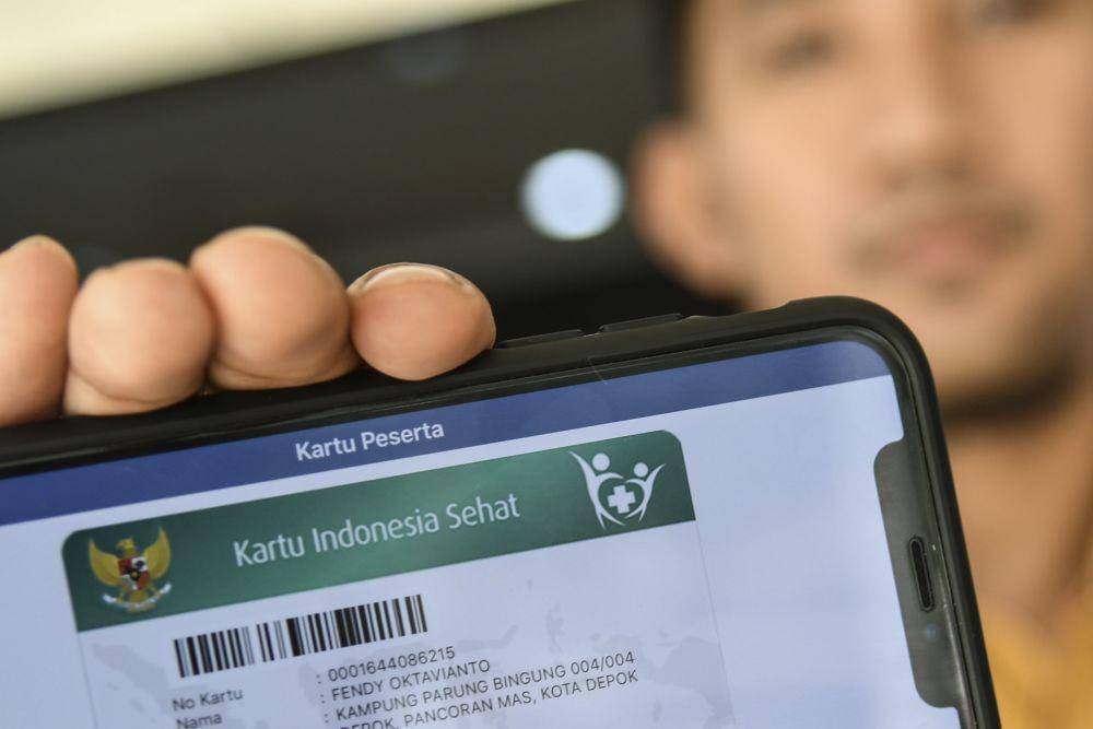 Petugas BPJS Kesehatan menunjukan kartu Jaminan Kesehatan Nasional (JKN) online miliknya di kantor Pelayanan BPJS Kesehatan Jakarta Selatan. (ANTARA FOTO/Muhammad Adimaja)