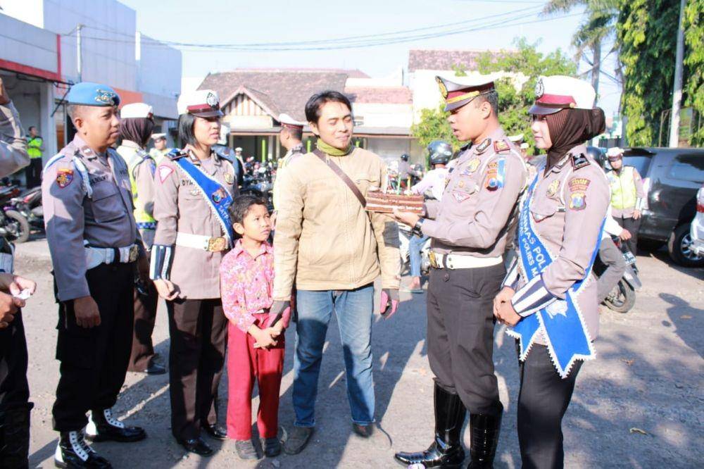 Kasatlantas Polres Madiun AKP Jimmy Heriyanto Manurung (dua dari kanan) menyerahkan kue tart bagi pengendara yang merayakan ulang tahun pada bulan Oktober 2019. Dok.IDN Times/Istimewa