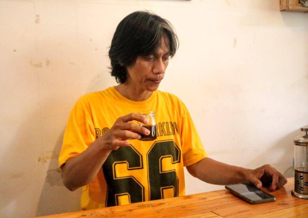 Wirastho pelukis menggunakan cete kopi sebagai pengganti cat. IDN Times/ Alfi Ramadana
