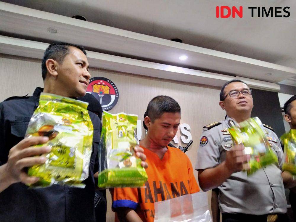 Wadirresnarkoba Polda Jatim AKBP Teddy Suhendiawan Syarif (kiri) dan Kabid Humas Polda Jatim Kombes Pol Frans Barung Mangera (kanan) mengapit tersangka GEP saat merilis kasus narkoba, Rabu (30/10). IDN Times/Ardiansyah Fajar.