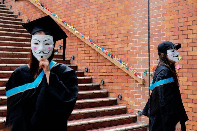 Mahasiswa menggunakan topeng Guy Fawkes berpose untuk pemotretan saat upacara kelulusan sebagai dukungan kepada pengunjuk rasa anti pemerintah di Universitas Politeknik Hong Kong, Hong Kong, pada 30 Oktober 2019. ANTARA FOTO/REUTERS/Tyrone Siu