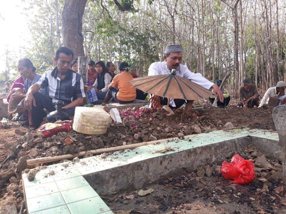 Sejumlah warga sedang berdoa di Makam Andini Ayuningtyas (5 bulan) korban penganiayaan yang dilakukan oleh ayahnya sendiri, Minggu (3/11). Dok.IDN Times/Istimewa