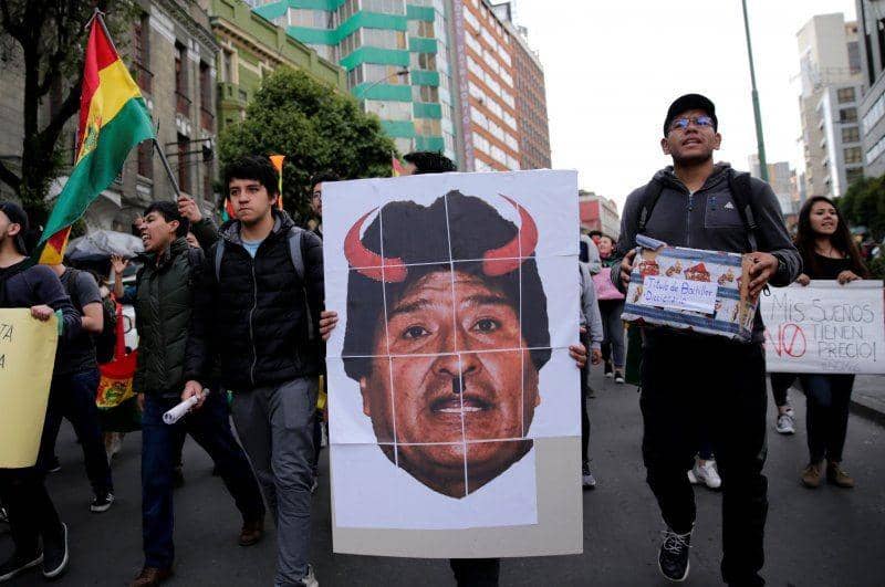 Demonstran membawa spanduk bergambar Presiden Bolivia Evo Morales dengan tanduk merak saat aksi protes di La Paz, Bolivia, pada 26 Oktober 2019. ANTARA FOTO/REUTERS/David Mercado