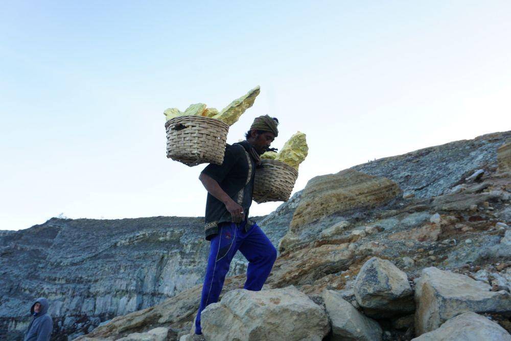 Seorang penambang tampak memikul hasil belerang dari Kawah Ijen. IDN Times/Mohamad Ulil Albab