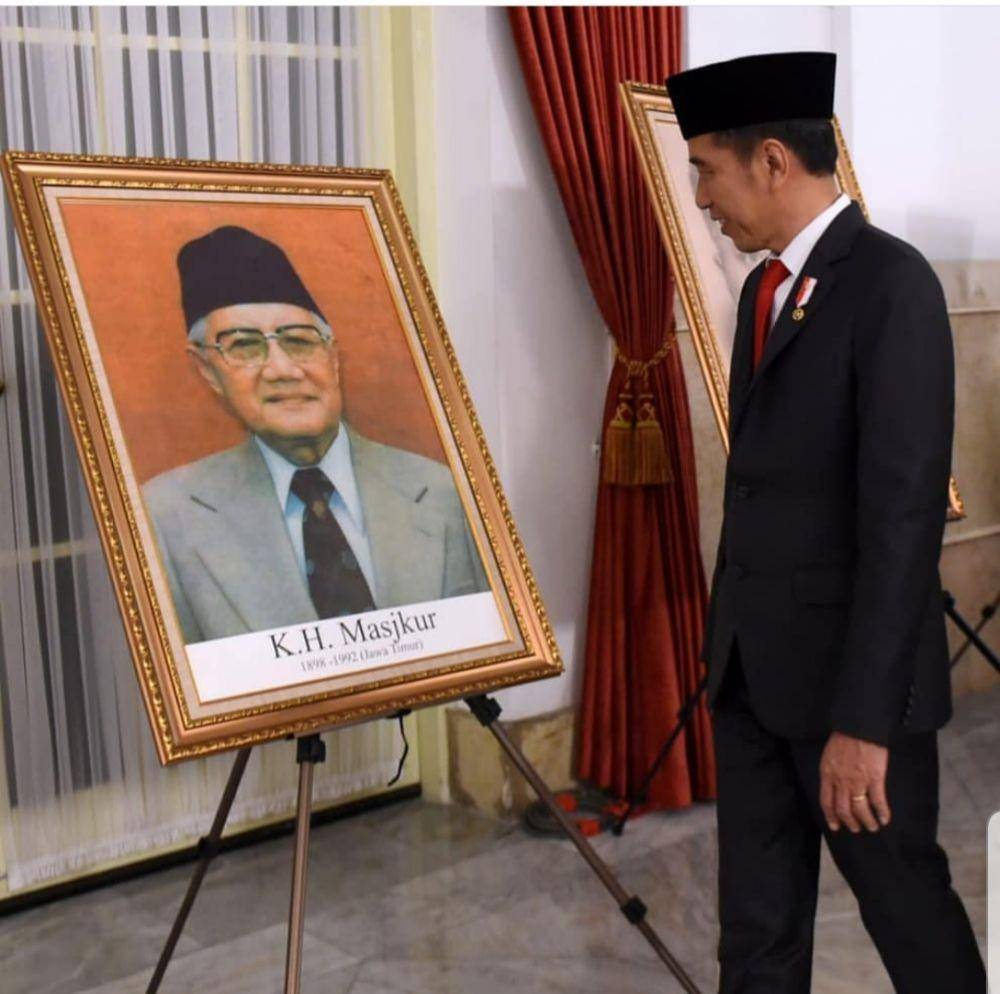 Presiden Joko Widodo memandangi foto KH Masjkur yang dianugerahi gelar pahlawan nasional, Jumat (8/11). Instagram.com/@khofifah.ip
