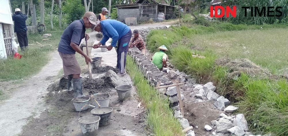 Ilustrasi pokmas mengerjakan pembangunan talut program padat karya. IDN Times/Daruwaskita