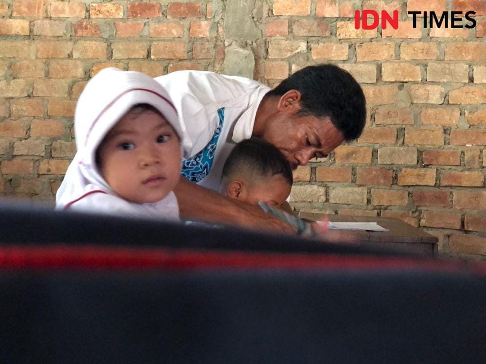 Suami dari Siti Komariah (29), Dika Arianto (39) membantu mengajar (IDN Times/Rangga Erfizal)