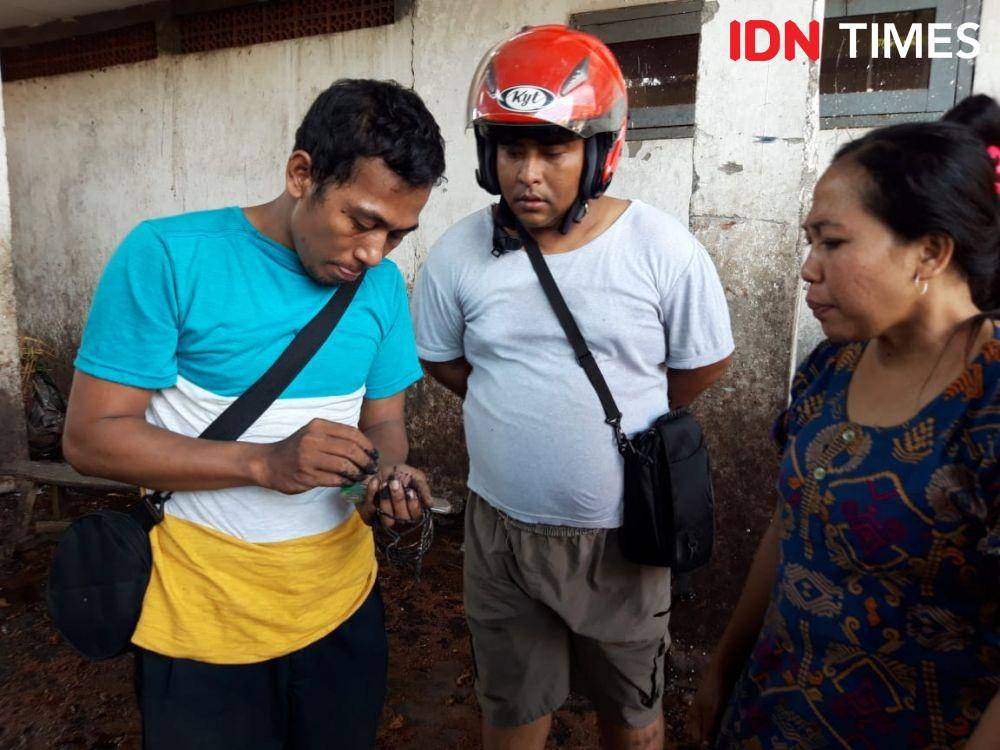 Saiful (kiri) menunjukkan barang yang berhasil ia selamatkan pada warga lain. IDN Times/Fitria Madia.