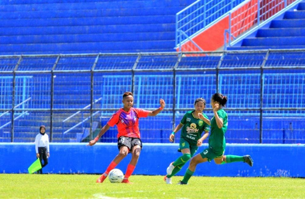 Pemain Arema FC putri, Jasmine Sefia (jersey merah) melepaskan tembakan saat menghadapi Persebaya. IDN Times/ Alfi Ramadana