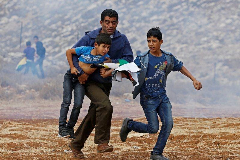 Warga Palestina melarikan dari dari gas air mata saat protes atas pemukiman Yahudi dekat Hebron, Tepi Barat, pada 15 November 2019. ANTARA FOTO/REUTERS/Mussa Qawasma