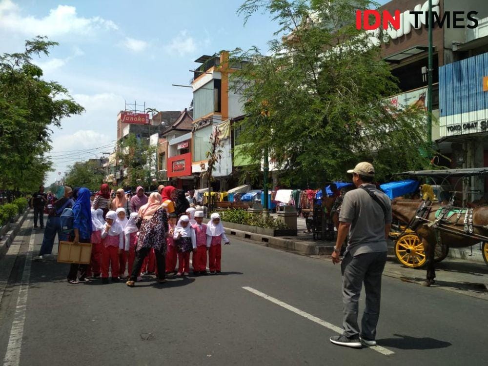 Sejumlah siswa taman kanak-kanak berpose di tengah jalan Malioboro yang lengang. IDN Times/Febriana Sinta