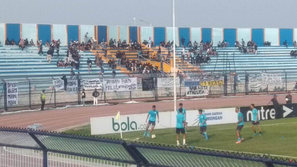 Sepanduk bertuliskan sindiran buat pemain dan manajemen Persela Lamongan terpasang di pagar tribun. IDN Times/Imron