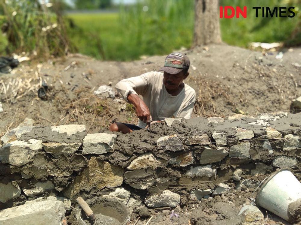 Seorang tukang sedang mengerjakan pembangunan talut padat karya di Dusun Djomblang. IDN Times/Daruwaskita