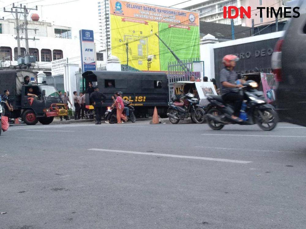 Dua kendaraan polisi memasuki area kampus HKBP Nomensen (IDN Times/Fadly Syahputra)