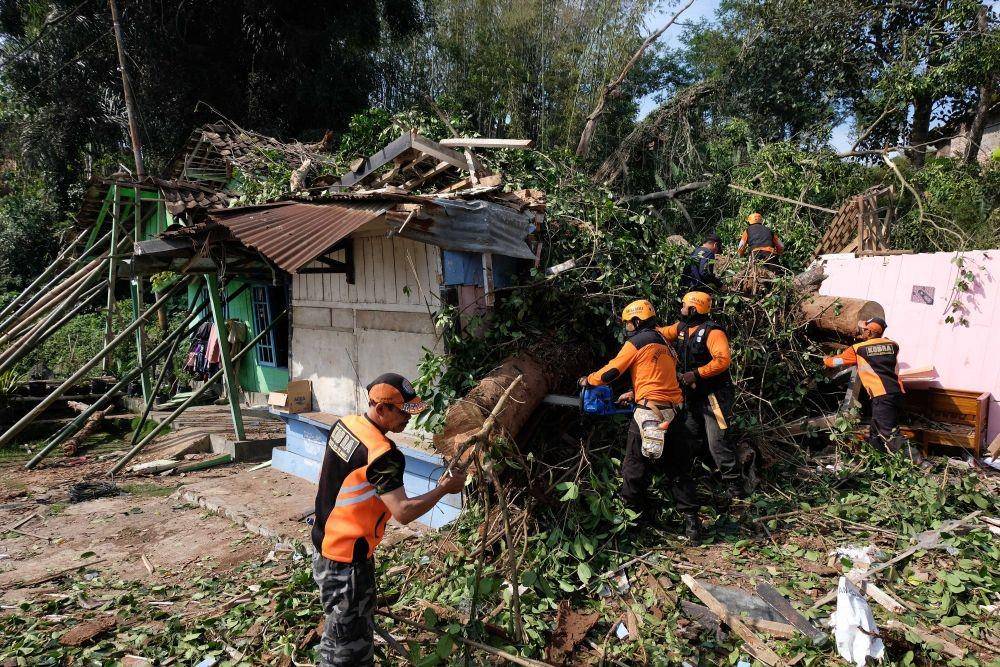 Tim SAR bersama relawan menyingkirkan batang pohon yang tumbang menimpa rumah warga di Beji, Petirejo, Ngadirejo, Temanggung, Jawa Tengah, 23/11/2019. ANTARA FOTO/Anis Efizudin