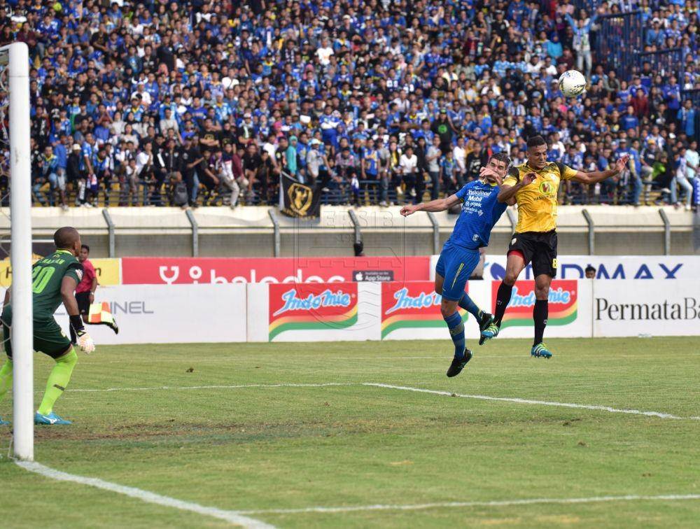 Pemain Persib, Frets Butuan sedang berebut bola dengan pemain Barito Putera, Minggu (24/11). persib.co.id