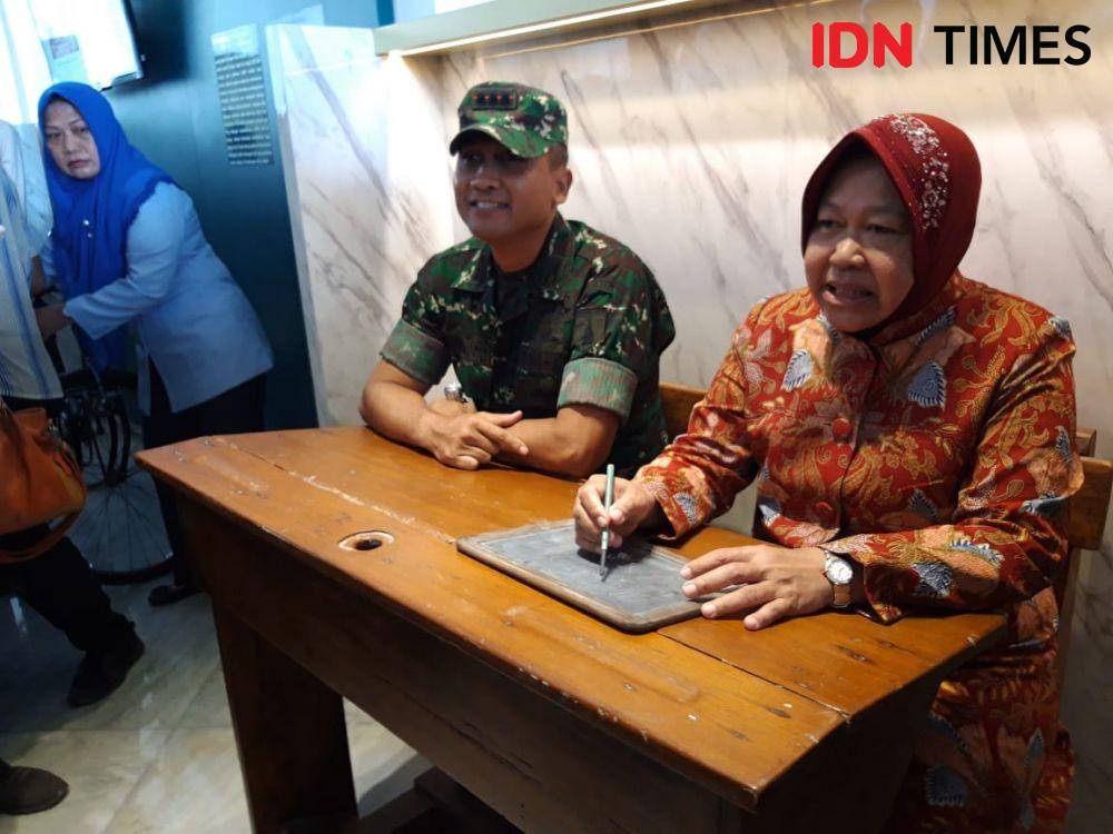 Wali Kota Surabaya Tri Rismaharini (kiri) dan Danrem 084 Bhaskarajaya Kolonel Inf Sudaryanto mencoba bangku sekolah yang jadi koleksi Museum Pendidikan, Senin (25/11). IDN Times/Fitria Madia