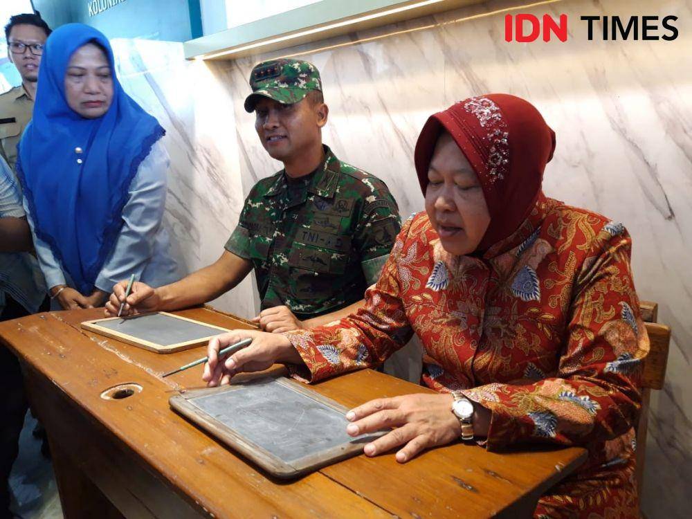 Wali Kota Surabaya Tri Rismaharini (kiri) dan Danrem 084 Bhaskarajaya Kolonel Inf Sudaryanto mencoba bangku sekolah yang jadi koleksi Museum Pendidikan, Senin (25/11). IDN Times/Fitria Madia