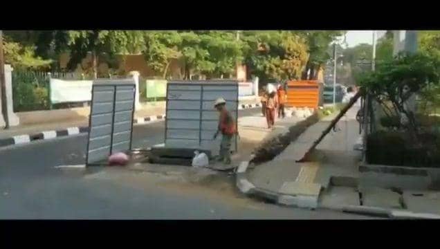 Petugas Bina Marga DKI Jakarta masukkan karung ke lubang galian (Dok. Istimewa)