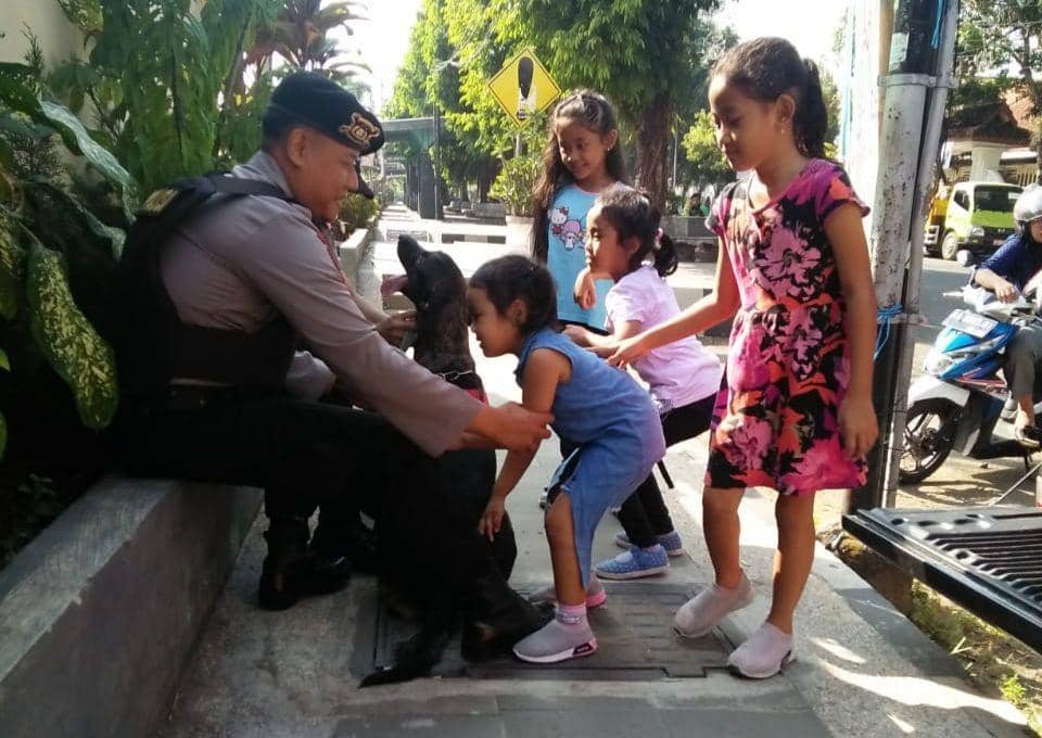 Anjing ras Belgian Malinois asik bermain dengan anak-anak dengan pendampingan Aipda Eko Puji Utomo, Bintara Unit Satwa Sat Samapta Polres Kebumen. (Istimewa)