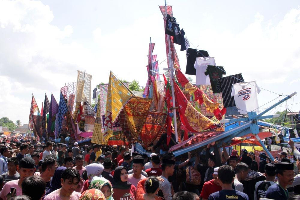 Sejumlah warga mengarak "julung-julung" (replika perahu) yang sudah dihias saat peringatan "Maudu Lompoa (Maulid Besar) di Desa Cikoang, Takalar, Sulawesi Selatan, Selasa (26/11/2019). Maudu Lompoa tersebut merupakan puncak peringatan Maulid Nabi Muhammad SAW yang dilaksakan setiap tahun oleh warga setempat dan menjadi salah satu objek wisata budaya Kabupaten Takalar. (ANTARA FOTO/Arnas Padda)