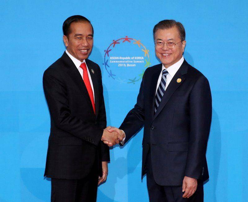Presiden Korea Selatan Moon Jae-in (ka) berjabat tangan dengan Presiden Indonesia Joko Widodo (ki) saat KTT ASEAN-Korea Selatan di Busan, Korea Selatan, pada 26 November 2019. ANTARA FOTO/Yonhap via REUTERS